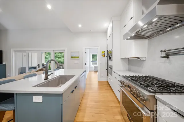 a kitchen with sink a stove and cabinets