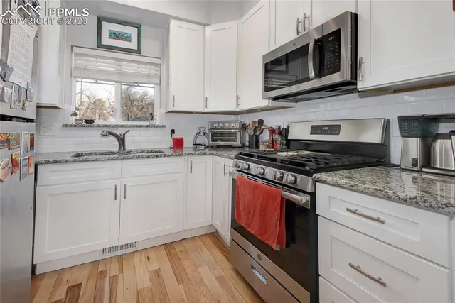 a kitchen with stainless steel appliances granite countertop a sink stove and microwave