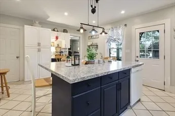 a kitchen with granite countertop a sink a center island and stainless steel appliances