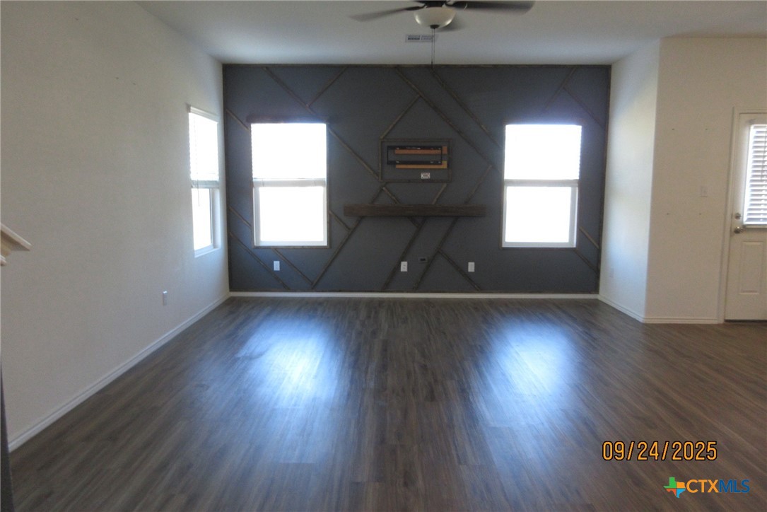 125 Greatest Gift Way Jarrell, TX 76537 - Photo 4 of 24 an empty room with wooden floor and windows