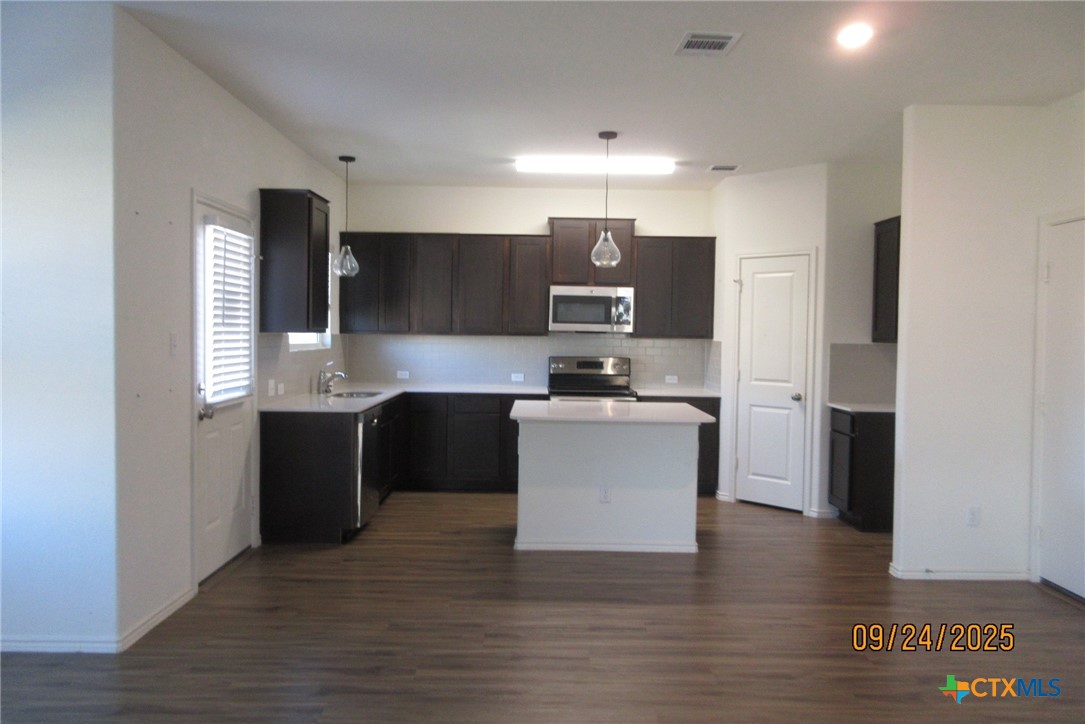 125 Greatest Gift Way Jarrell, TX 76537 - Photo 5 of 24 a kitchen with kitchen island stainless steel appliances a sink cabinets and a counter top space