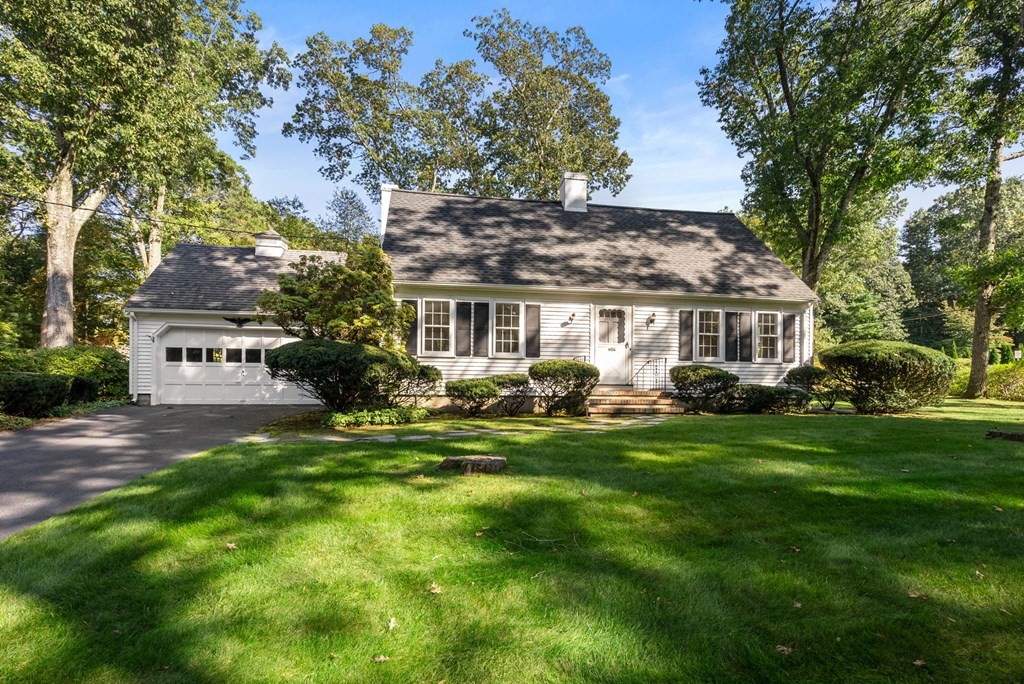 a front view of a house with yard and green space
