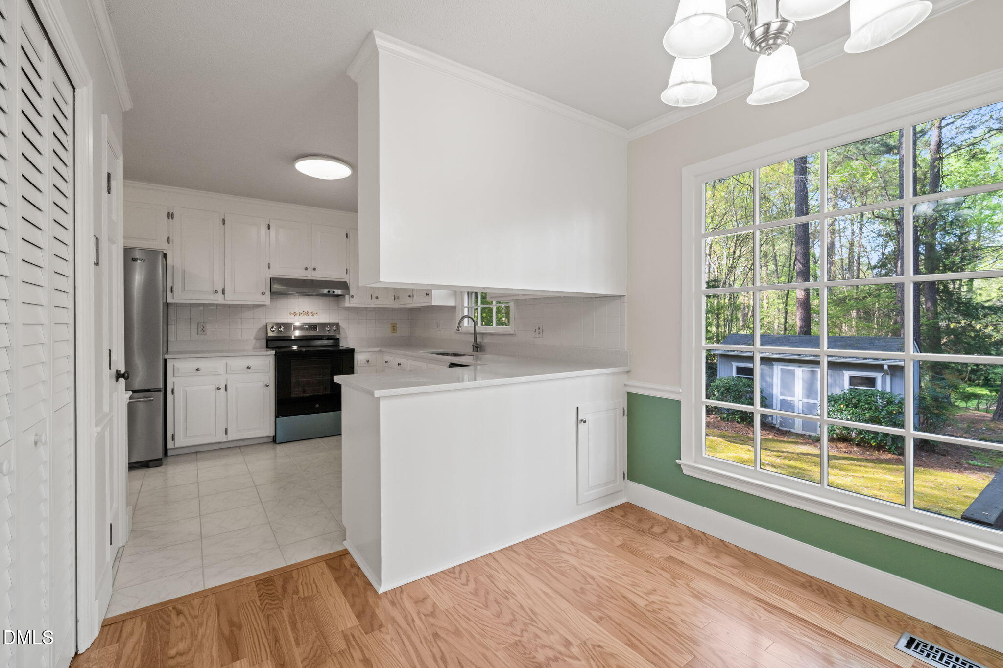 6115 Winthrop Drive Raleigh, NC 27612 - Photo 10 of 41 a kitchen with a sink cabinets stainless steel appliances and a large window