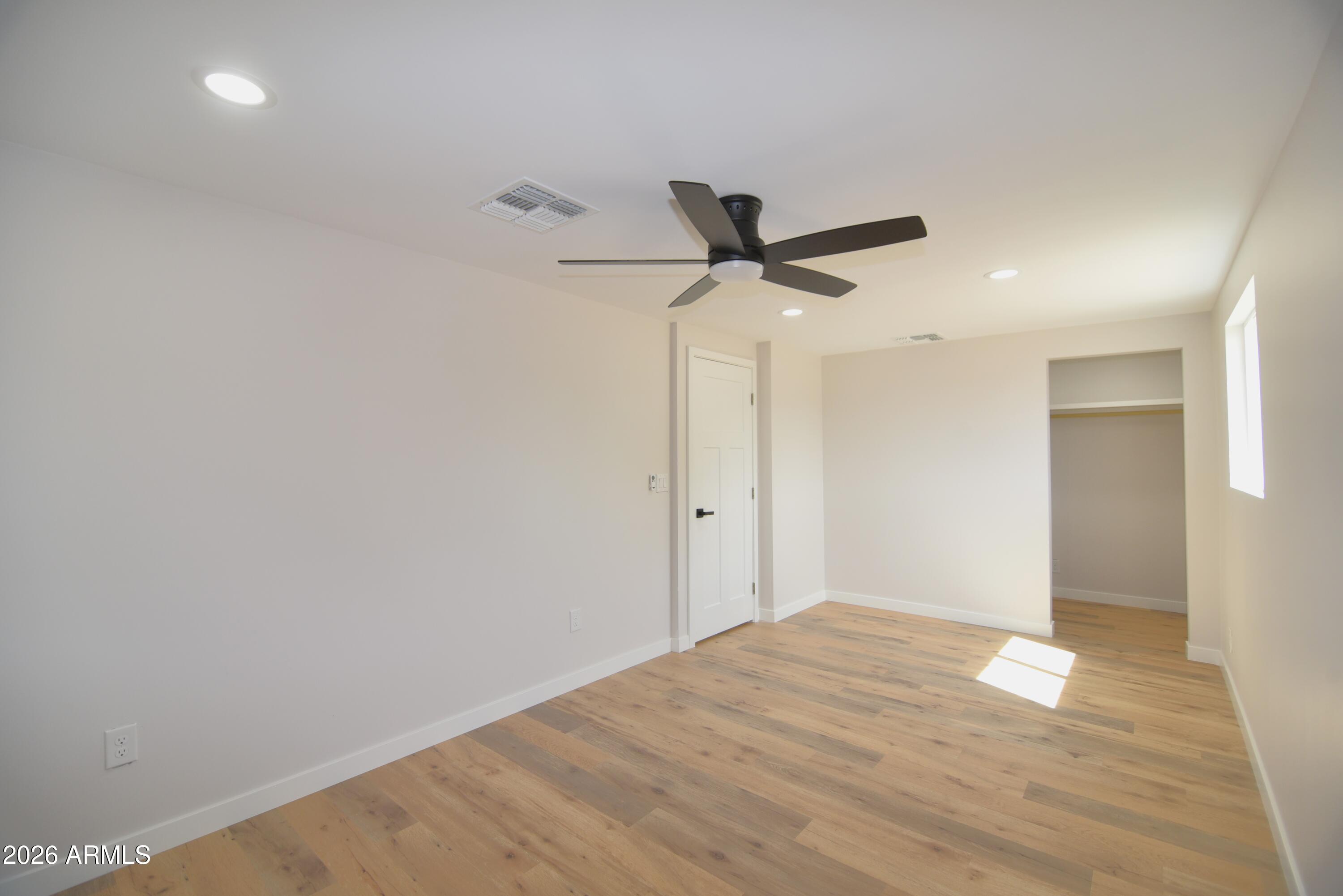 508 South 98th Street Mesa, AZ 85208 - Photo 16 of 34 a view of a big room with wooden floor and a ceiling fan