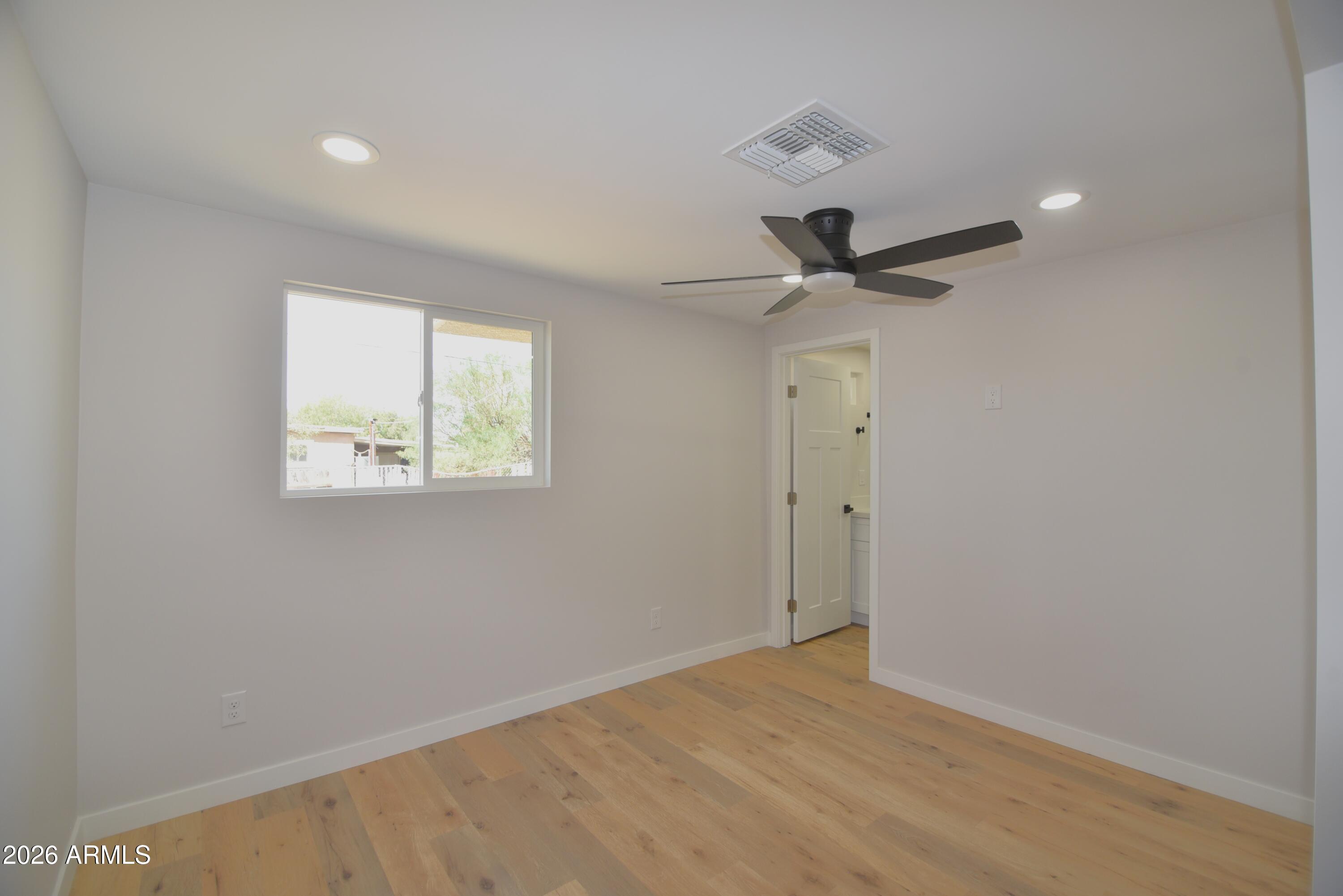 508 South 98th Street Mesa, AZ 85208 - Photo 20 of 34 an empty room with wooden floor and ceiling fan