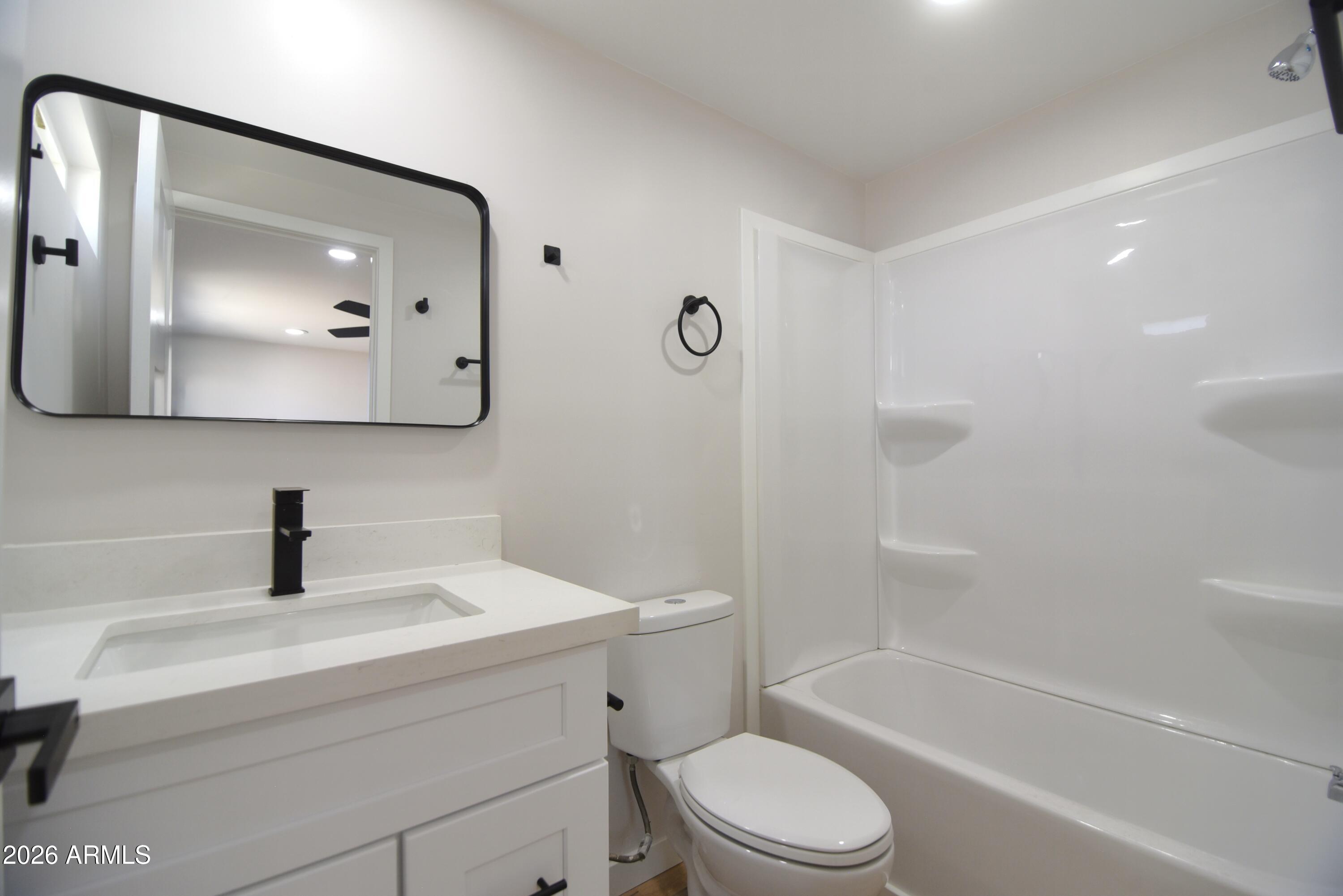 508 South 98th Street Mesa, AZ 85208 - Photo 21 of 34 a bathroom with a toilet a sink a mirror a bathtub and vanity