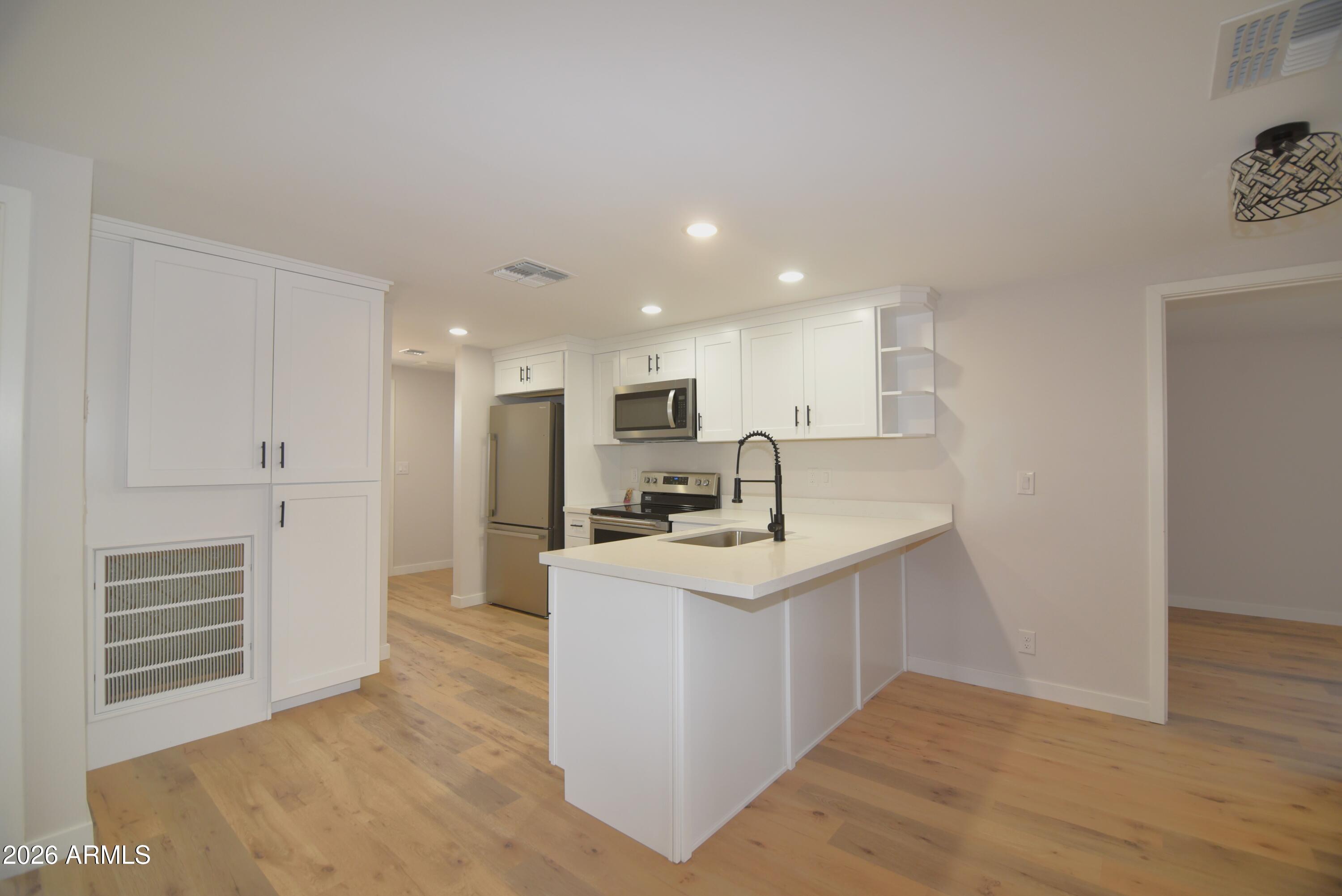 508 South 98th Street Mesa, AZ 85208 - Photo 5 of 34 a kitchen with stainless steel appliances granite countertop a sink a stove and a refrigerator