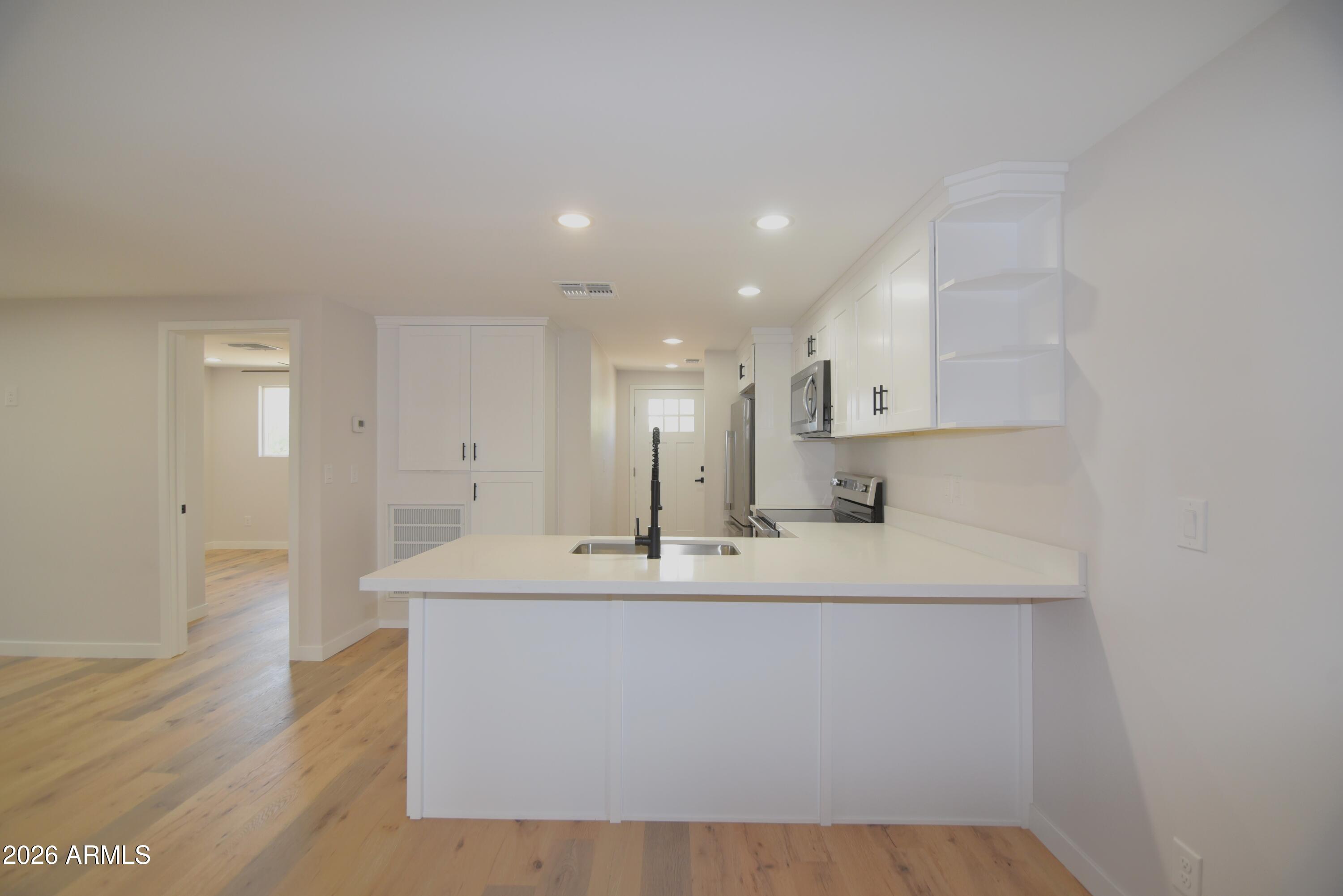 508 South 98th Street Mesa, AZ 85208 - Photo 7 of 34 a large white kitchen with wooden floor