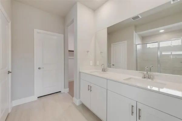 a bathroom with double sink and a mirror