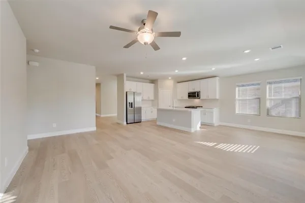 a view of a livingroom with kitchen appliances and furniture