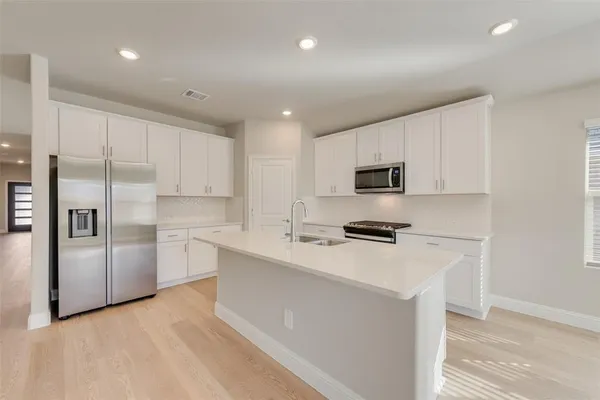 a kitchen with stainless steel appliances a refrigerator stove microwave and sink
