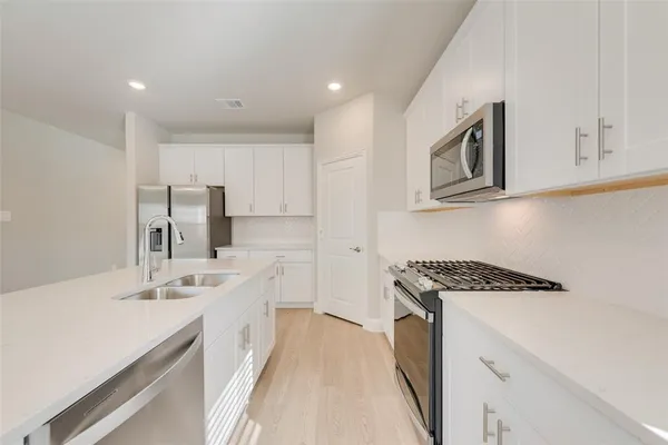 a kitchen with a sink stove top oven and cabinets