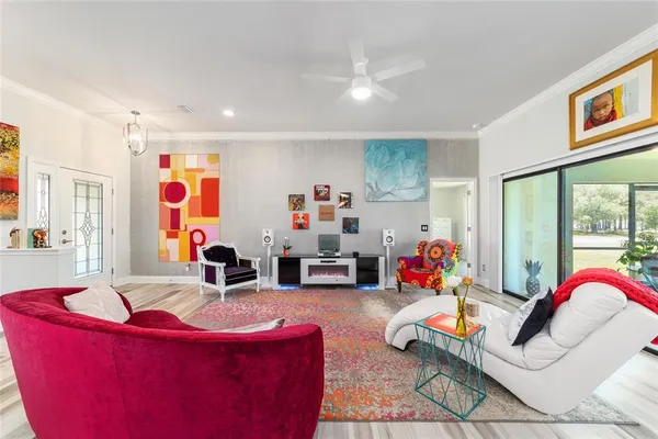 a living room with furniture kitchen view and a chandelier