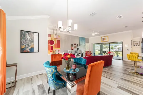 a kitchen with stainless steel appliances kitchen island granite countertop a refrigerator a stove top oven a sink dishwasher and white cabinets with wooden floor