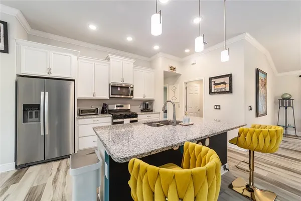 a kitchen with stainless steel appliances kitchen island granite countertop a refrigerator and a stove top oven