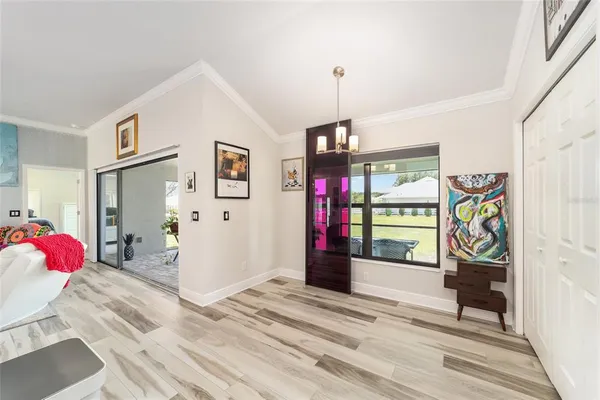 a view of a hallway with wooden floor and a bathroom