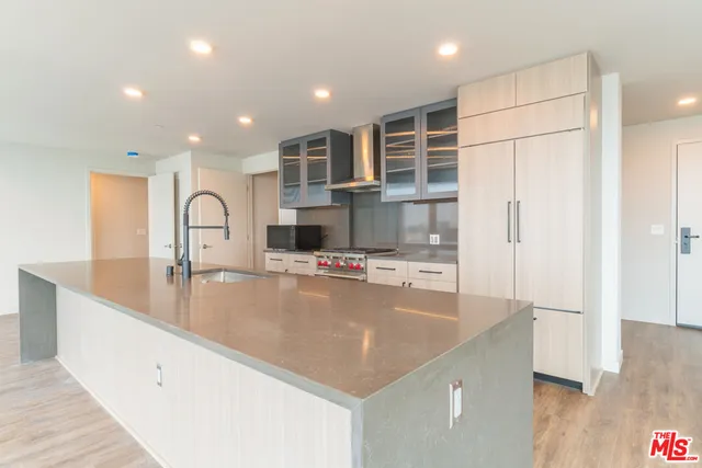 a view of kitchen with stainless steel appliances granite countertop a sink and a refrigerator