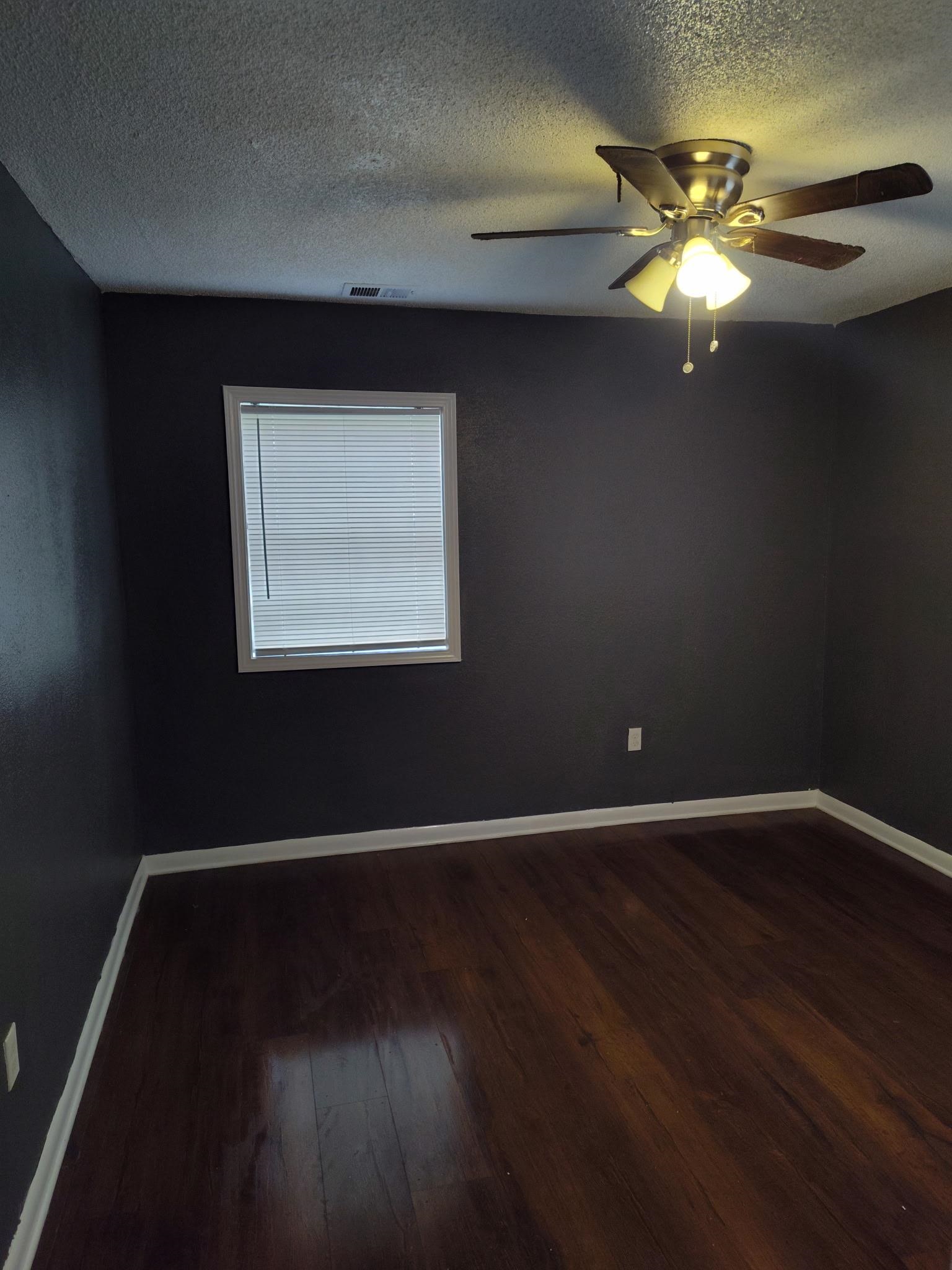 258 Silverage Avenue Memphis, TN 38109 - Photo 6 of 8 Empty room featuring dark wood finished floors, a textured ceiling, and ceiling fan