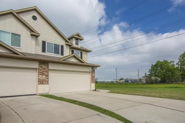 a front view of a house with a garden and trees