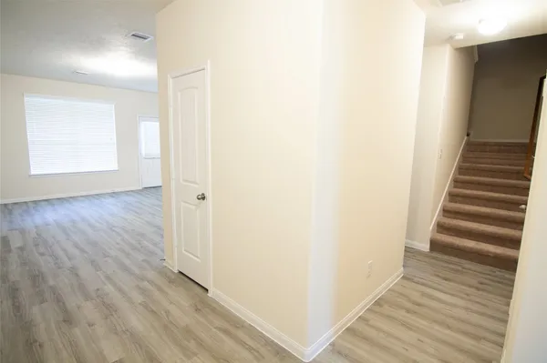 a view of a hallway with wooden floor and entryway