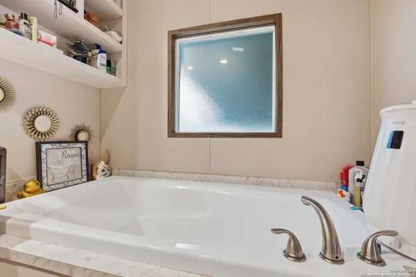 a bathroom with a tub sink and mirror