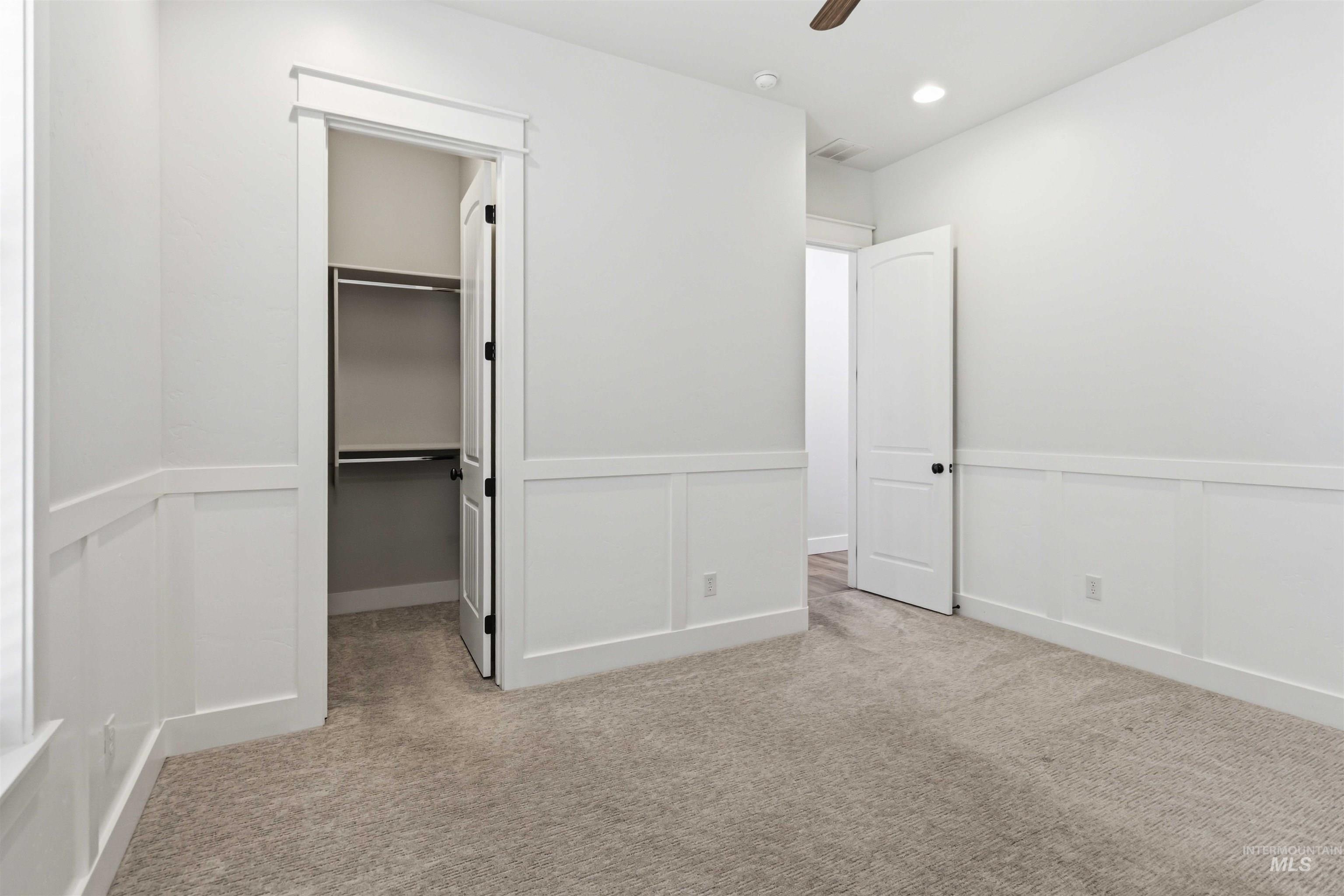 3218 North Cherry Laurel Way Star, ID 83669 - Photo 30 of 50 Carpeted room featuring a tray ceiling with recessed lighting and a ceiling fan, white baseboards, and a doorway with white trim