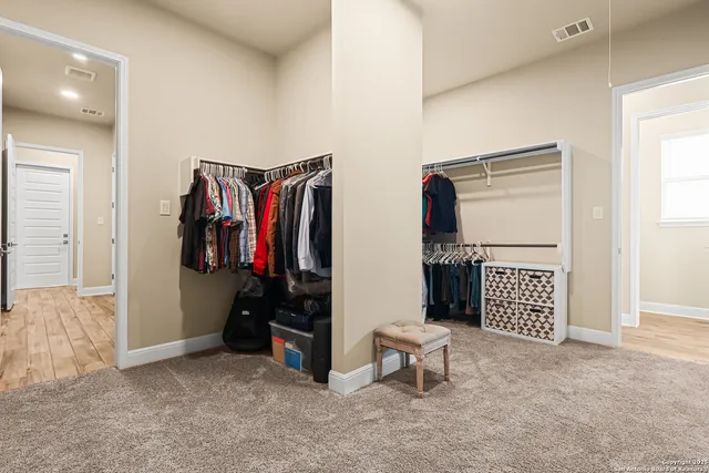 a view of walk in closet with clothes and shoes