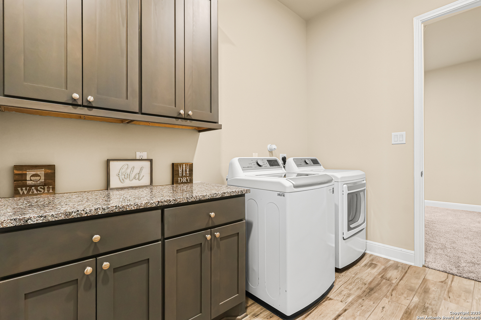 27103 Coltons Canyon San Antonio, TX 78260 - Photo 33 of 42 a utility room with granite countertop cabinets washer and dryer