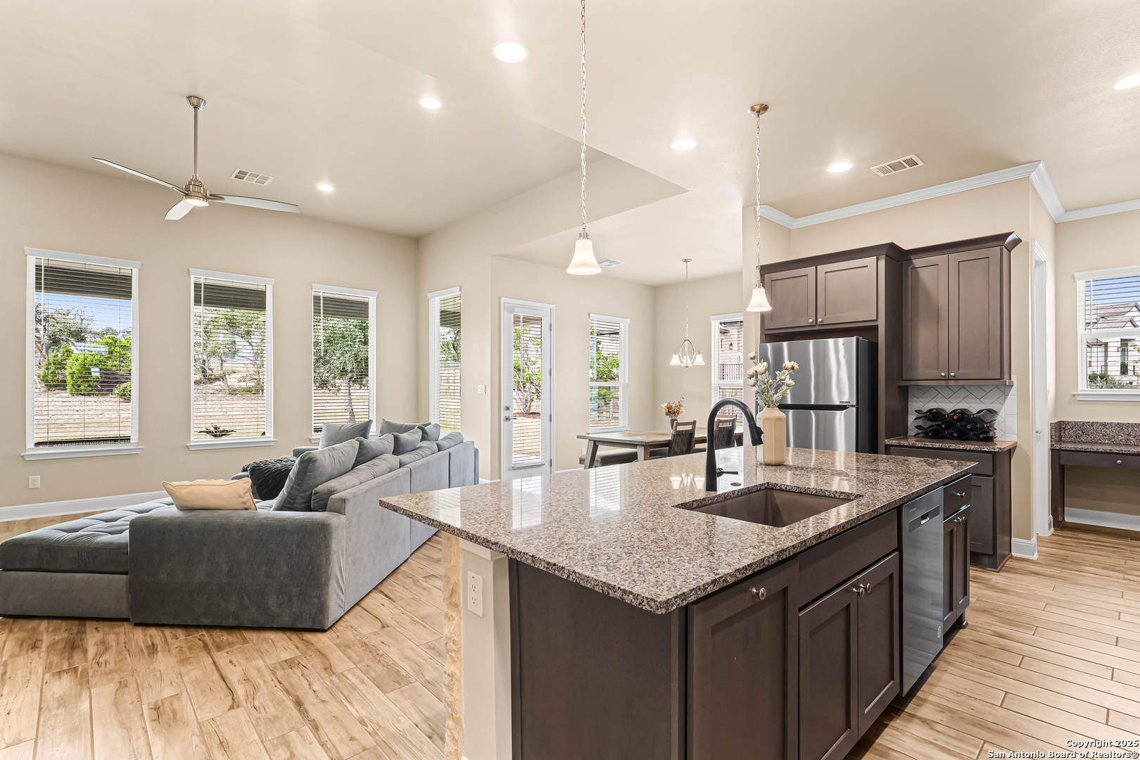 27103 Coltons Canyon San Antonio, TX 78260 - Photo 7 of 42 a large kitchen with kitchen island a large counter top space a sink stainless steel appliances and windows