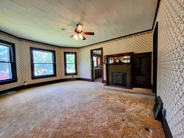 a view of an empty room with a fireplace and a window