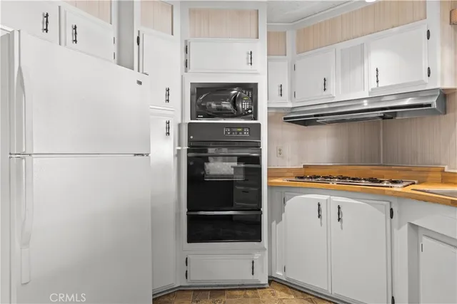 a large kitchen with stainless steel appliances granite countertop a large counter top and a refrigerator