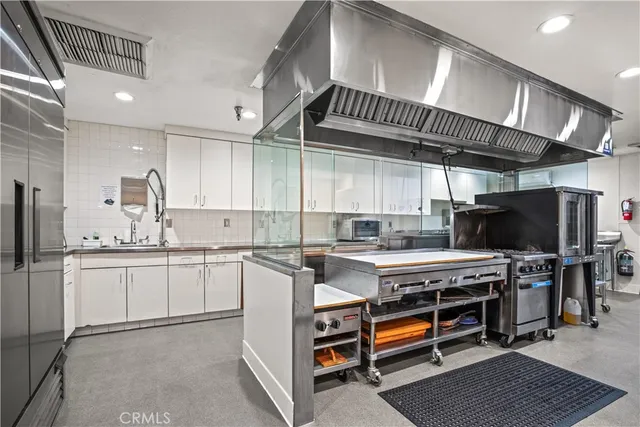 a kitchen with stainless steel appliances granite countertop a refrigerator and a stove