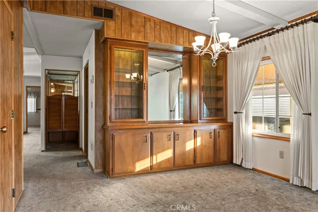 a kitchen with stainless steel appliances a table chairs refrigerator and sink
