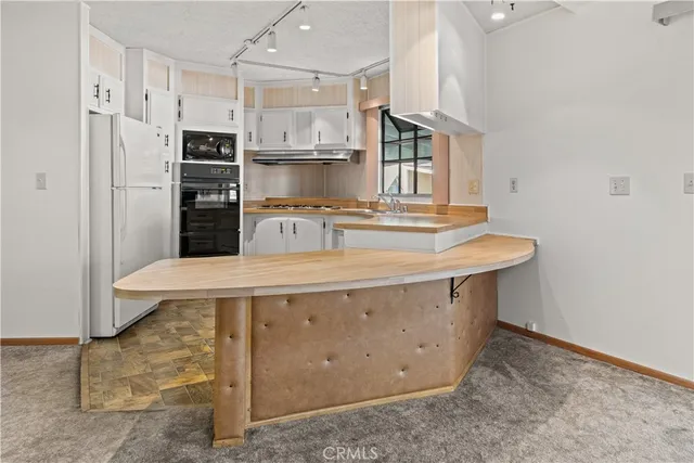 a kitchen with stainless steel appliances granite countertop a sink a stove a refrigerator and cabinets