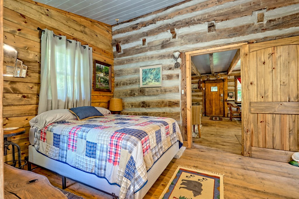 1064 Muskrat Creek Road Hayesville, NC 28904 - Photo 27 of 67 a bedroom with a bed and wooden floor