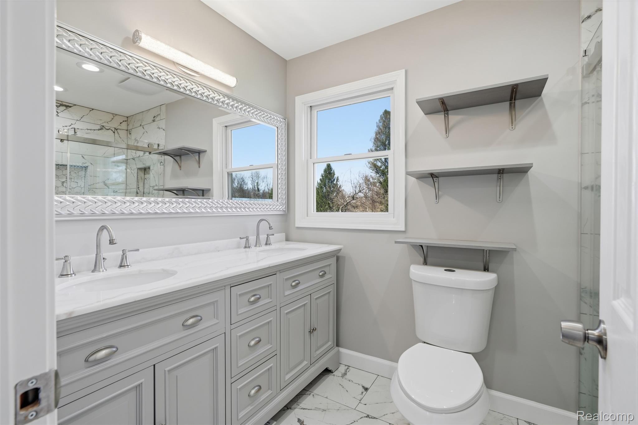 8636 Tindall Road Davisburg, MI 48350 - Photo 28 of 61 Bathroom featuring double vanity, light marble finish floors, and a marble finish shower