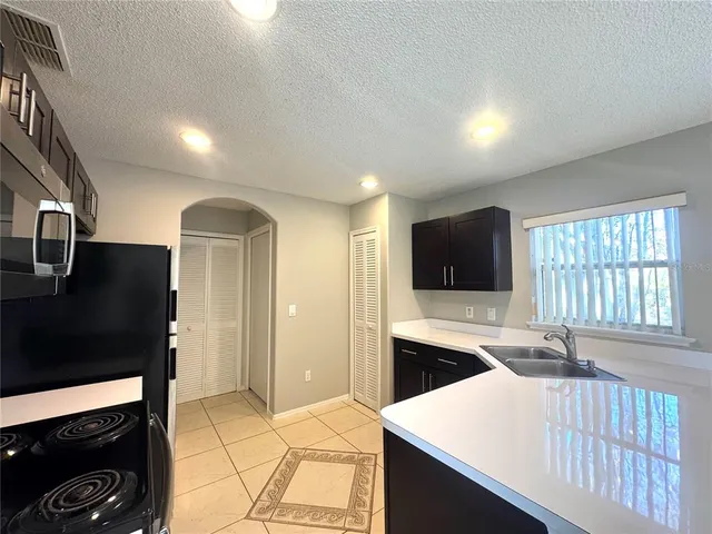 a kitchen with stainless steel appliances kitchen island granite countertop a refrigerator and a stove top oven