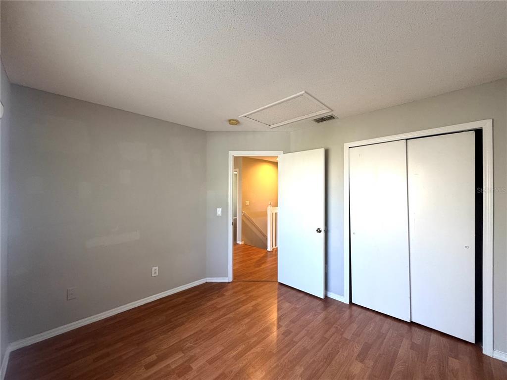 14328 Rainsong Drive Orlando, FL 32824 - Photo 14 of 27 a view of an empty room with wooden floor and a window