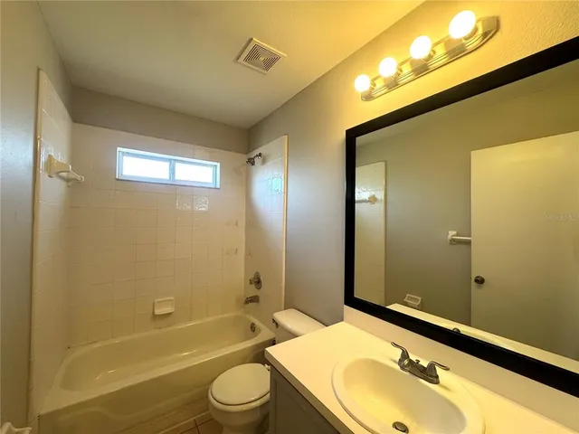 a bathroom with a sink mirror toilet and bathtub