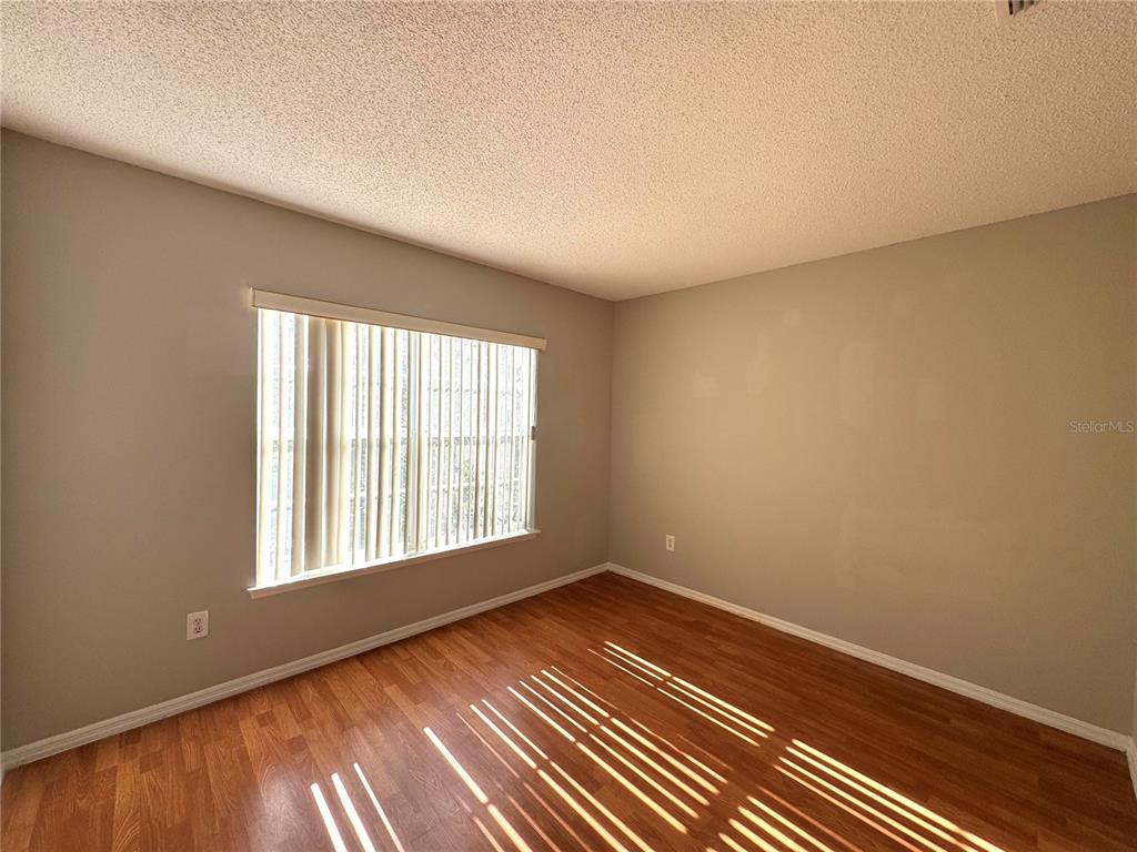 14328 Rainsong Drive Orlando, FL 32824 - Photo 18 of 27 wooden floor in an empty room with a window
