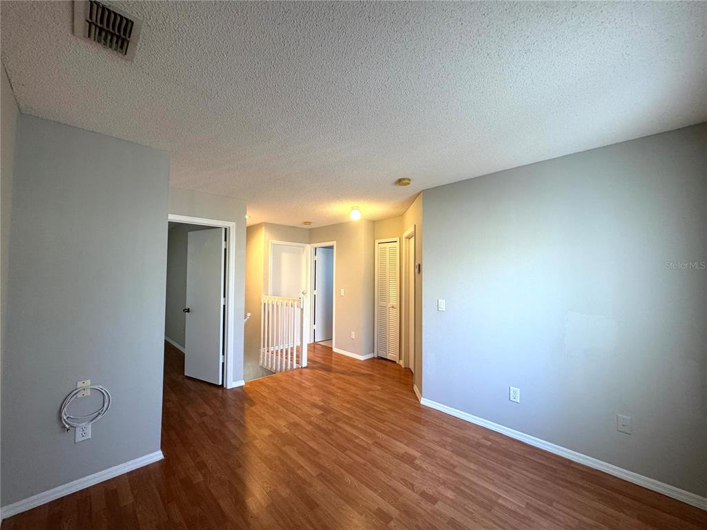 14328 Rainsong Drive Orlando, FL 32824 - Photo 20 of 27 a view of an empty room with wooden floor and a window