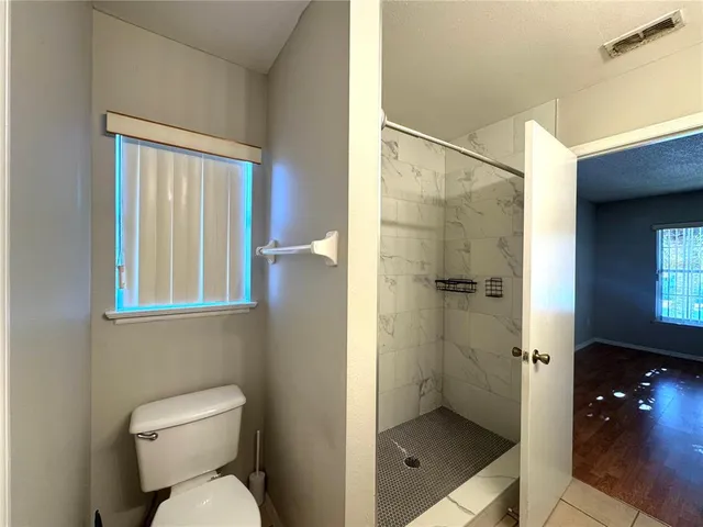 a bathroom with a toilet and a shower