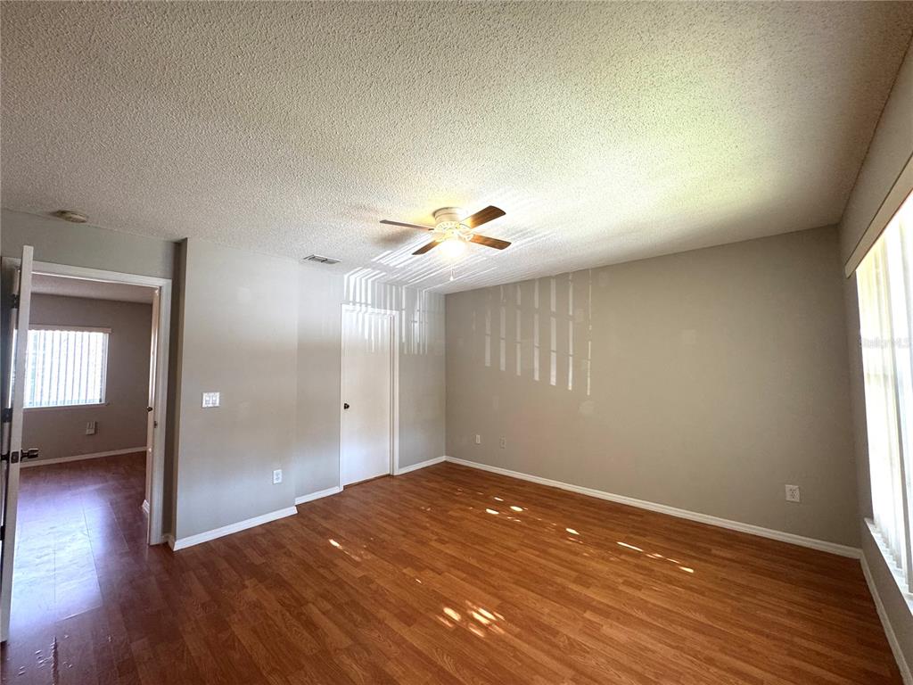 14328 Rainsong Drive Orlando, FL 32824 - Photo 25 of 27 wooden floor in an empty room with a window