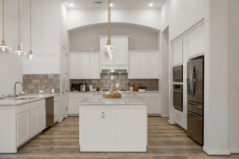 a kitchen with a sink refrigerator and cabinets