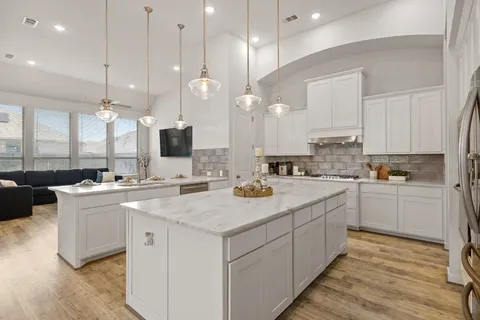 a kitchen with a sink a counter top space a large window and stainless steel appliances
