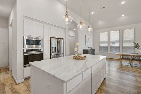 a kitchen with sink stove and refrigerator