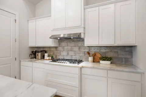 a kitchen with white cabinets and white appliances