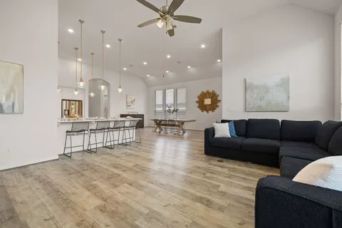 a living room with furniture and a view of kitchen