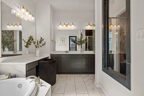a spacious bathroom with a bathtub sink and mirror