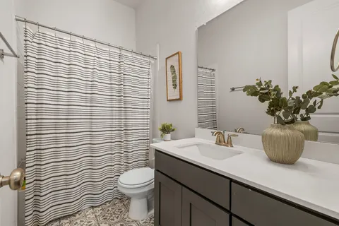 a bathroom with a sink a toilet and shower curtain